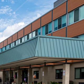 Exterior view of a modern hospital building with blue and orange facade.