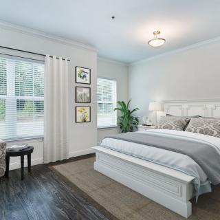 A modern bedroom with a comfortable bed, large windows, and stylish decor.