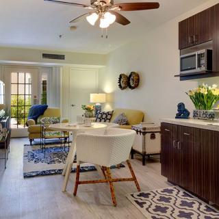 A cozy open-plan living and kitchen area with modern furnishings and bright lighting.