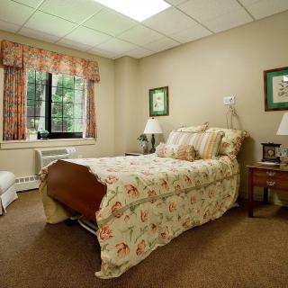 A cozy bedroom with floral bedding and soft lighting.