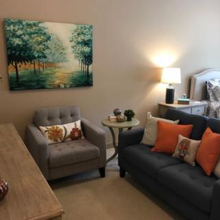 A cozy living room with a sofa, armchair, and decorative elements.
