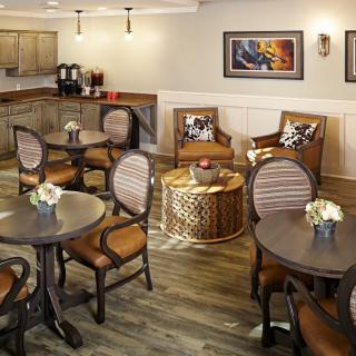A cozy seating area with round tables, cushioned chairs, and elegant decor.