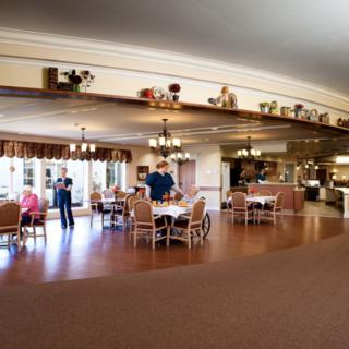 Spacious dining area with people gathered around tables.