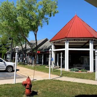 A view of a building with a striking red roof beside a fire hydrant in a landscaped area.