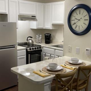 A compact apartment kitchen with a dining counter set for two.