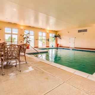 A cozy indoor pool area with seating and natural light filtering through large windows.