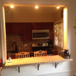 A cozy kitchen with a countertop seating area and warm lighting.