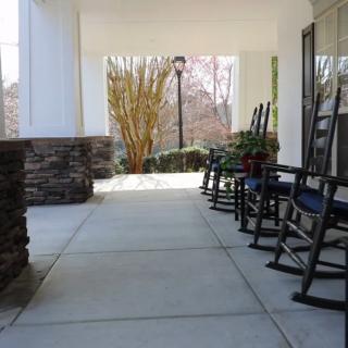 A row of rocking chairs on a covered porch.