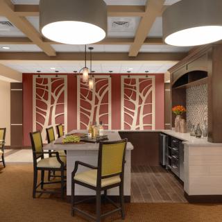 A modern kitchen with contemporary design elements, featuring a central island, stylish chairs, and decorative lighting.