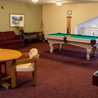 A cozy game room featuring a pool table and seating area.