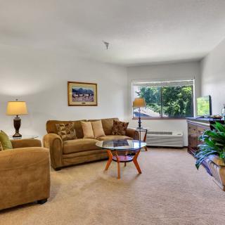 A cozy living room with a sofa, coffee table, and large window.