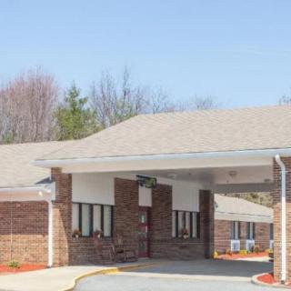 A brick building with an overhang at the entrance and a driveway.