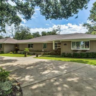 A suburban house with a spacious driveway and well-maintained lawn.