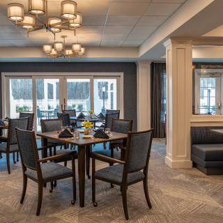 A modern dining room with elegant furniture and large windows.