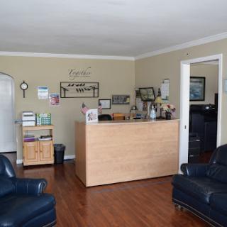 A welcoming reception area featuring comfortable seating and a wooden front desk.