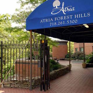 Entrance to Atria Forest Hills with a blue awning.
