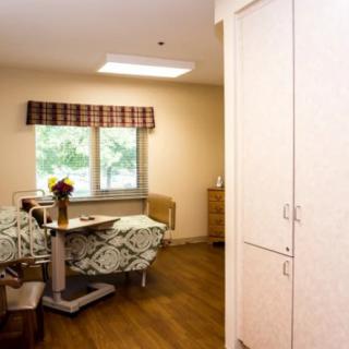A cozy room interior with chairs, a table, and a cabinet near a window.