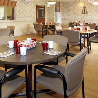 A cozy dining area with neatly arranged tables and chairs, set for a meal.