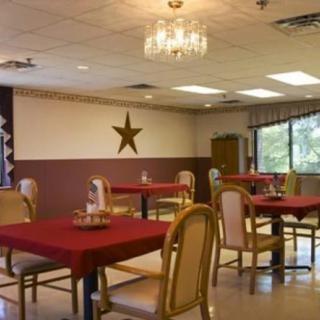 An empty dining room with red tablecloths and a star wall decoration.