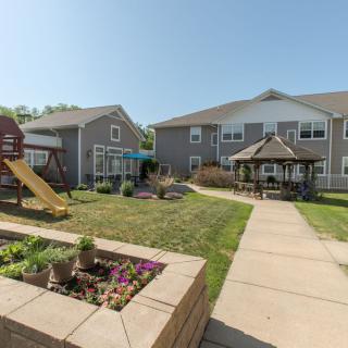 A residential courtyard featuring a playground, gazebo, and landscaped gardens.