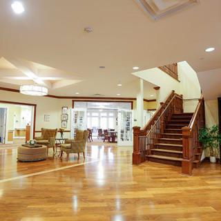 A spacious living room featuring a wooden staircase, elegant furniture, and warm lighting.