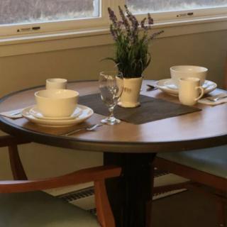 A cozy table set for two with coffee cups and a decorative plant.
