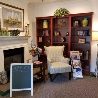 A cozy living room with a fireplace, bookshelves, and a comfortable chair.