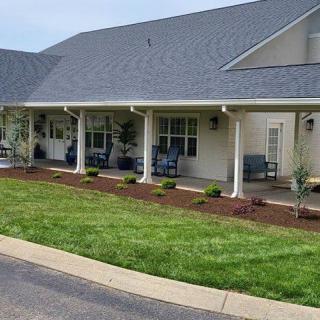 A residential house with a porch and neatly maintained lawn.