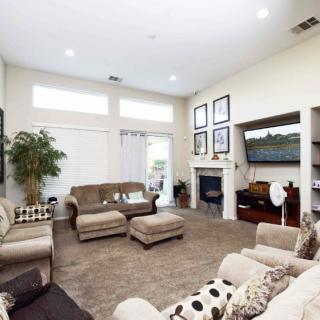 A spacious living room with comfortable seating, a large television, and elegant decor, creating a cozy and welcoming atmosphere.
