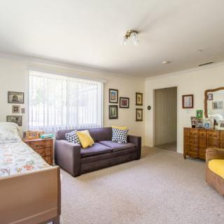 A cozy living space with a bed, couch, and various decorations.