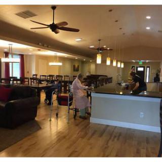 A spacious lounge area with a bar counter, seating arrangements, and ceiling fans.