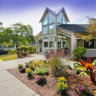 A modern building with well-maintained landscaping and vibrant garden plants.