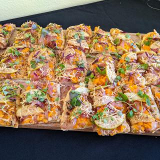 A platter of gourmet pizza slices with colorful toppings.