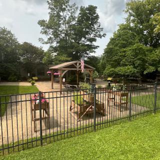 A serene outdoor space featuring fenced seating areas surrounded by lush greenery.