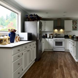 A modern kitchen with white cabinets and stainless steel appliances.