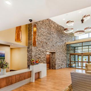 A modern lobby featuring a stone accent wall, stylish lighting fixtures, and comfortable seating.