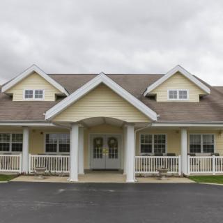 A front view of a residential house with a porch and gabled roof.