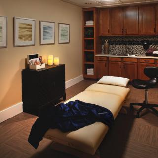 A cozy massage room designed for relaxation and therapy, featuring comfortable furnishings and a tranquil atmosphere.