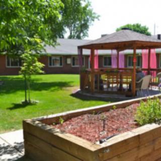 A serene garden area featuring a wooden gazebo and well-maintained landscaping.