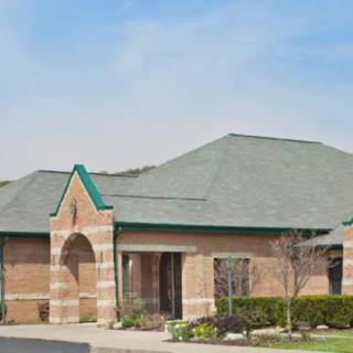 A brick office building with a pitched roof and landscaped surroundings.