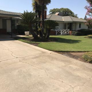 A suburban house with a driveway and well-maintained lawn.