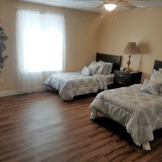 A cozy bedroom with two twin beds, a nightstand, and soft lighting.