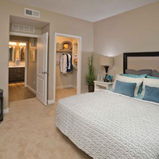 A cozy and well-decorated bedroom featuring a neatly made bed and a stylish closet.