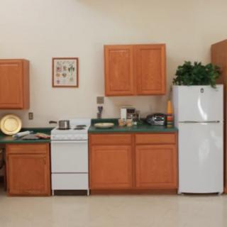 A cozy kitchen setup with wooden cabinets, a white fridge, and a stove.
