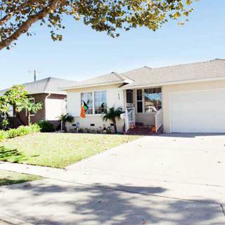 A suburban house with a well-kept front yard and driveway on a sunny day.