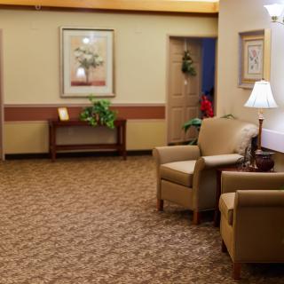 A cozy waiting area with chairs, a lamp, and decorative elements.