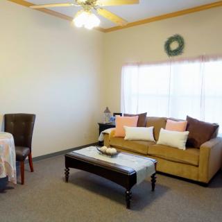A cozy living room with a sofa, coffee table, and dining area.
