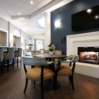 A modern living room featuring a fireplace, stylish furniture, and a dining area.