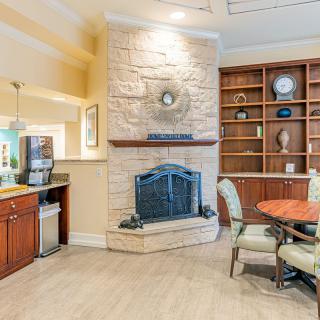 A cozy living room with a stone fireplace, built-in bookshelf, and comfortable seating area.