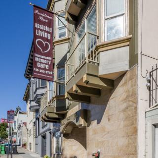 A street view of a building with a sign for assisted living and a community cafe.